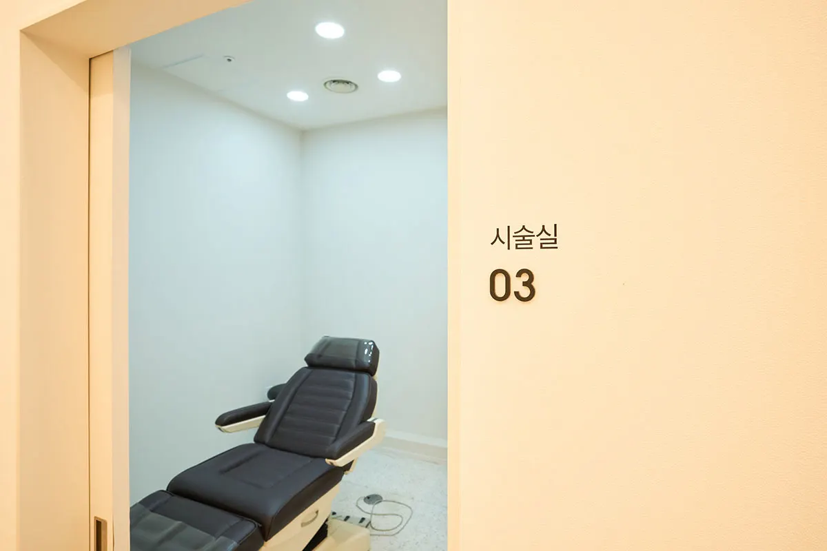 시술실 03 표시가 붙은 방과 눕힐 수 있는 진료 의자